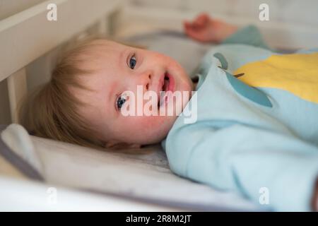 Bambino sorridente con sindrome di Down che guarda la macchina fotografica Foto Stock
