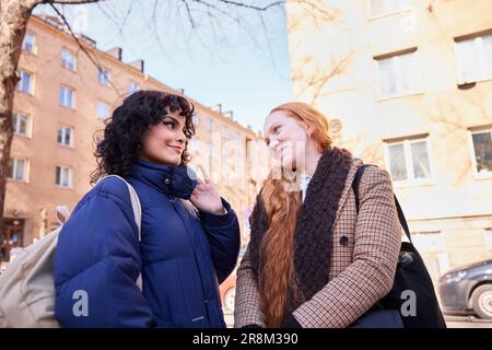 Amiche femminili che sorridono e si guardano Foto Stock
