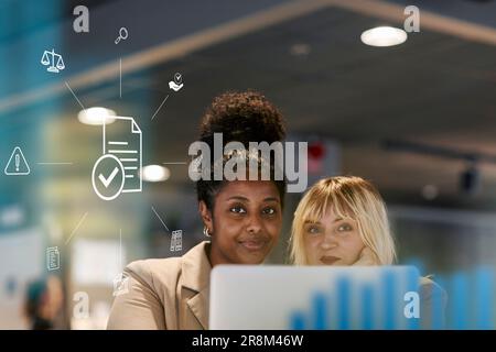 Colleghi sorridenti in ufficio, icona del computer documentato in primo piano Foto Stock