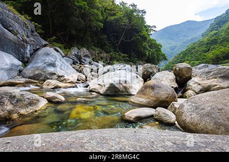 Foto idilliaca di un ruscello che scorre attraverso la valle del Parco Nazionale di Taroko. L'acqua setosa cade su grandi pietre, creando una scena serena. Allo Shak Foto Stock