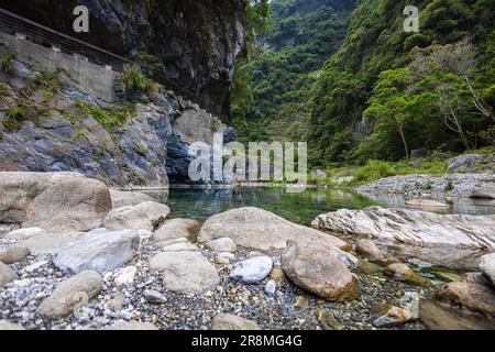 Foto idilliaca di un ruscello che scorre attraverso la valle del Parco Nazionale di Taroko. L'acqua setosa cade su grandi pietre, creando una scena serena. Allo Shak Foto Stock