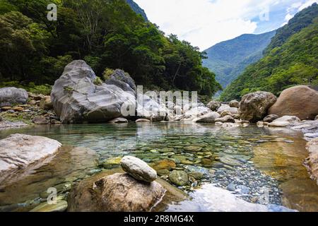 Foto idilliaca di un ruscello che scorre attraverso la valle del Parco Nazionale di Taroko. L'acqua setosa cade su grandi pietre, creando una scena serena. Allo Shak Foto Stock