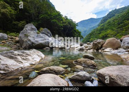 Foto idilliaca di un ruscello che scorre attraverso la valle del Parco Nazionale di Taroko. L'acqua setosa cade su grandi pietre, creando una scena serena. Allo Shak Foto Stock