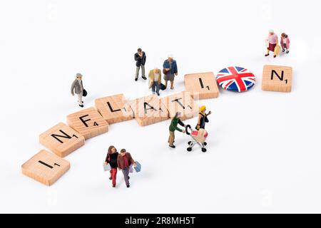 Inflazione - lettere di legno Scrabble disposte per incantare 'inflazione' circondato da piccole figurine che raffigurano vari gruppi di età. Foto Stock