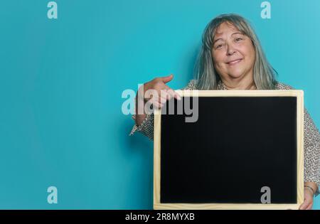 Donna anziana dai capelli bianchi che tiene una lavagna con spazio per copiare il testo Foto Stock