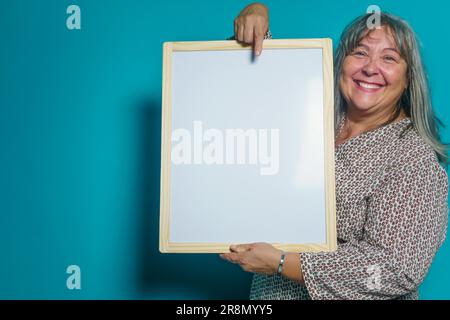 Donna più vecchia dai capelli bianchi che tiene una lavagna bianca per incollare il testo sopra Foto Stock