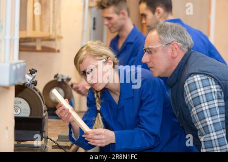 La donna come apprendista durante la lezione di falegnameria in officina Foto Stock