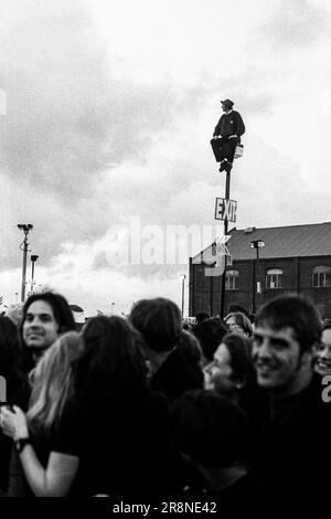 Un uomo in Galles, una maglietta di rugby sale un lampione per avere una visione migliore della folla al BBC Big Noise Festival di Cardiff Bay, Cardiff, Wales, UK domenica 11 maggio, 1997. Foto: Rob Watkins Foto Stock