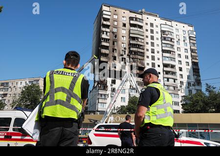 KIEV, UCRAINA - 22 GIUGNO 2023 - gli agenti di polizia sono raffigurati all'esterno di un condominio di 16 piani nel quartiere di Dniprovskyi danneggiato da un esplosione Foto Stock