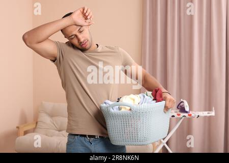 Cesto pieno di panni sporchi in lavanderia Foto stock - Alamy