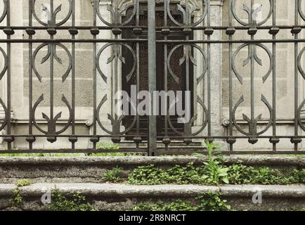 cancello in ferro battuto e scalini all'ingresso di una chiesa abbandonata Foto Stock