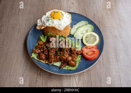 Asian dishe culinary Still Life. Loc Lac con carne tritata in wok, riso, pomodori, cetrioli e limone Foto Stock