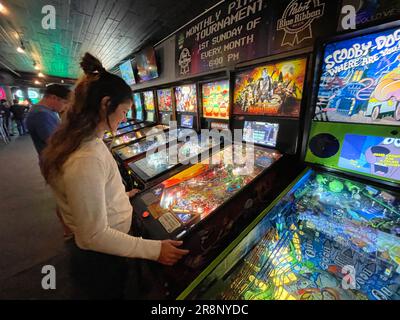 Persona non identificata che gioca ai videogiochi e beve birra nel bar 1up di Denver, Colorado Foto Stock