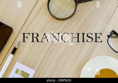 Concetto di business e finanza Vista dall'alto di lente d'ingrandimento, occhiali da vista, una tazza di caffè, calcolatrice, penna e telefono cellulare su sfondo di legno scritto con Foto Stock