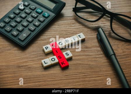 Concetto aziendale. Crossword alfabetico di profitti, perdite e rischi. Foto Stock