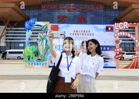 (230622) -- VIENTIANE, 22 giugno 2023 (Xinhua) -- i giovani di Lao prendono selfie prima di salire a bordo del treno dell'UEM a Vientiane, Laos, 21 giugno 2023. Gli studenti del Laos hanno acquisito maggiore comprensione dei treni elettrici a più unità (EMU) di Lane Xang sulla ferrovia Cina-Laos, mentre si godono il loro primo viaggio. Un evento a tema 'vedere il mondo in treno' lanciato dalla società cinese CRRC Corporation Limited, il produttore dei treni Lane Xang EMU per la ferrovia Cina-Laos, ha organizzato il viaggio dalla capitale del Laos di Vientiane alla città patrimonio dell'umanità di Luang Prabang Mercoledì. PER ANDARE CON 'Feature: Lao Youth le Foto Stock