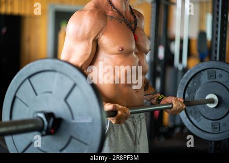 Foto con spazio copia di un uomo irriconoscibile che fa pesi con un bar Foto Stock