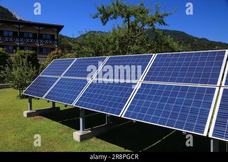 Pannelli solari montati su telaio nel cortile accanto a una casa privata. Produzione di energia fotovoltaica nei pressi di Salisburgo, Austria. Foto Stock
