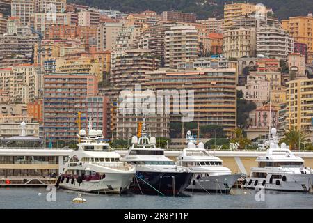 Monaco - 2 febbraio 2016: Yacht di lusso ormeggiati nel porto di Hercule presso gli edifici residenziali del grattacielo di un giorno d'inverno sullo sfondo. Foto Stock