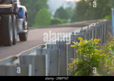 recinzione a bordo strada con sfondo sfocato del passaggio dei camion di carburante, risorse grafiche sfondi per il trasporto di risorse in luce naturale Foto Stock