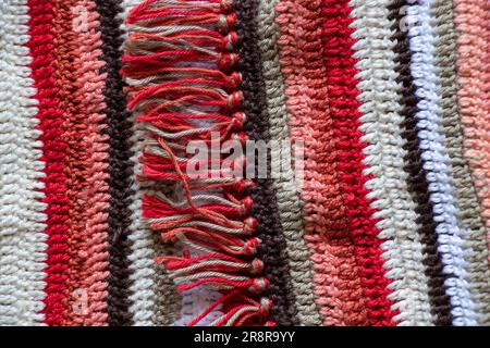 tappeto nonna a righe colorate multicolore rosso bianco nero come sfondo, tappeto da pavimento Foto Stock