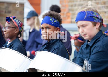 Londra, Regno Unito. 22nd giugno, 2023. I bambini della band Kinetika Bloco suonano padelle in acciaio e strumenti in ottone davanti al monumento commemorativo della guerra in Windrush Square, Brixton. Questo fa parte degli eventi per commemorare il 75th° anniversario dell'arrivo dell'Impero Windrush ai moli di Tilbury. Credit: Anna Watson/Alamy Live News Foto Stock