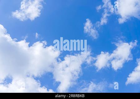 Foto affascinante che mostra un cielo blu radioso con nuvole di cotone che si infrangono. La tonalità blu brillante simboleggia infinite possibilità e libertà Foto Stock