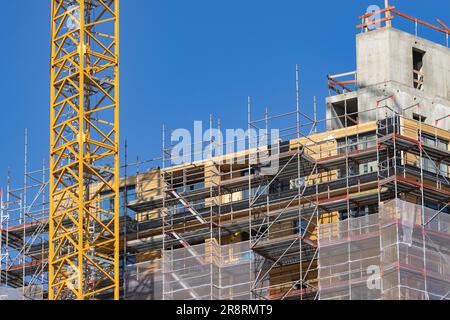cantiere di un alto edificio in legno con una gru Foto Stock