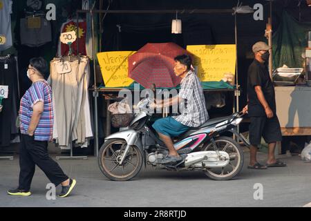 SAMUT PRAKAN, THAILANDIA, Mar 03 2023, un anziano guida in moto attraverso il mercato Foto Stock