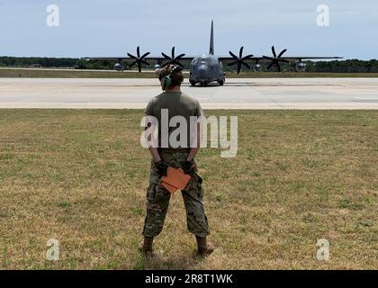 Westhampton Beach, New York. 21/06/2023, STATI UNITI Air Force National Guard Senior Airman Eric Wolf del 106th Rescue Wing in attesa di segnalare al HC-130J Combat King II di procedere in avanti per il decollo, il 21 giugno 2023 a F.S Gabreski ANGB a Westhampton Beach, New York. Il C-130J e il suo equipaggio stanno assistendo la guardia costiera nella ricerca di un sommergibile perso mentre si tuffano vicino al relitto del Titanic. ( STATI UNITI Air National Guard foto del capitano Cheran Campbell) Credit: Jeremy Hogan/Alamy Live News Foto Stock