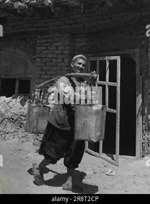 Kurdistan - Medio Oriente pericolo Spot -- l'acqua è sempre un problema a Mosul. Ancora una volta l'onnipresente tino di benzina dell'ex esercito è impressionato - questa volta da un vettore itinerante dell'acqua. Agosto 19, 1949. (Foto di stampa pittorica). Foto Stock