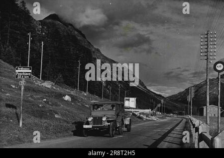 Pontresina - la vita nelle alte Alpi della Svizzera. Le "Jeep" svizzere sono chiamate "Willys" -- questa marca svizzera di auto leggera è molto simile all'auto americana per tutti gli scopi di guerra. E' ammirevole per le strade ripide e tortuose del paese. Il cartello all'estremità orientale di Pontresina mostra la strada per il passo del Bernina e Poschiavo, alla frontiera italiana. 22 gennaio 1948. (Foto di Pictorial Press). Foto Stock