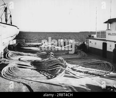 "Ecco la salsa? Il cavo telefonico simile a uno spaghetto è disposto in modo ordinato sul ponte del traghetto Valcour, pronto per la posa sul lago Champlain. La liscia spirale facilitò il lavoro di posa del cavo da 000 metri tra Grand Isle, VT., e Cumberland Head, N.Y. Una settimana di lavoro si preparò per l'operazione, che impiegò solo quattro ore. Il cavo raddoppia i circuiti telefonici tra il Vermont e New York. 12 febbraio 1955. (Foto di United Press Photo). Foto Stock