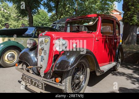 Una Austin Seven rossa degli anni '1930 con una maniglia di avviamento che sporge dalla griglia del radiatore. Austin Ruby ad una mostra d'auto d'epoca. Foto Stock