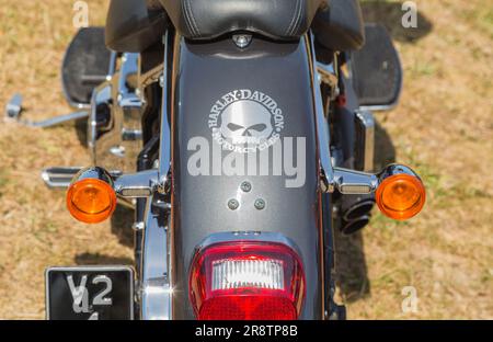 Primo piano di un paraspruzzi posteriore di una moto Harley Davidson decorato con il nome iconico e il motivo stilizzato del cranio. Biker, libertà o viaggio su strada. Foto Stock