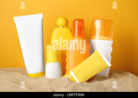 Molti prodotti di terra diversi su sabbia su sfondo arancione Foto Stock