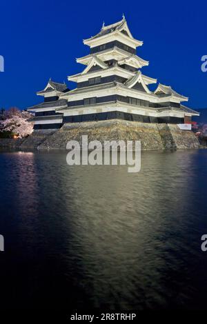 I ciliegi fioriscono di notte e la luna al castello di Matsumotojo, tesoro nazionale Foto Stock