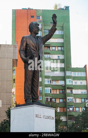 Una statua di U.S. Il presidente Bill Clinton contro i blocchi di appartamenti in cemento a Pristina, in Kosovo Foto Stock