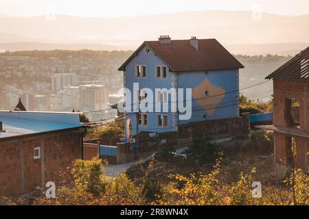Una casa patriottica con una mappa del Kosovo nei colori nazionali dipinti sul suo lato, in cima a una collina nella capitale Pristina Foto Stock