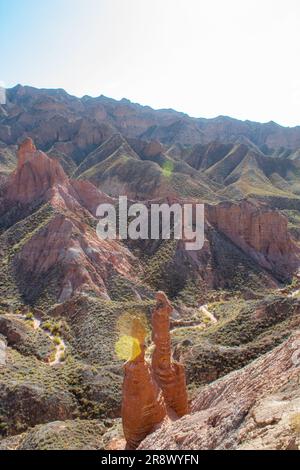 Paio di natura sculture in Danxia Binggou Canyon rilievi in Zhangye, Sunan Regione, Provincia di Gansu, Cina. Pietra arenaria rossa rocce del Geoparco. Rosso Foto Stock