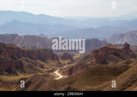 Vista aerea da fuco di Danxia Binggou Canyon rilievi in Zhangye, Sunan Regione, Provincia di Gansu, Cina. Sharp picchi appuntiti nel Geoparco. Strada a V Foto Stock