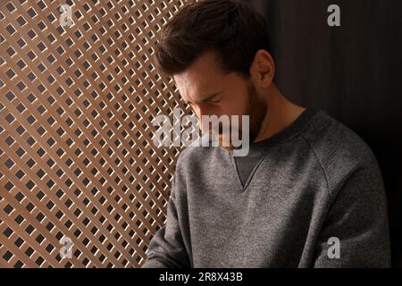 Sconvolgente l'uomo che ascolta il sacerdote durante la confessione in cabina, spazio per il testo Foto Stock