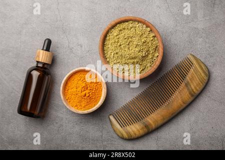 Composizione a posa piatta con henné e polvere di curcuma su tavolo grigio chiaro. Colorazione naturale dei capelli Foto Stock