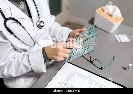 Medico di sesso femminile toccare tablet trasparente con diagnostica medica digitale sullo schermo Foto Stock