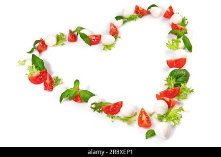 Forma del cuore di mozzarella di pomodoro con basilico isolato su sfondo bianco Foto Stock