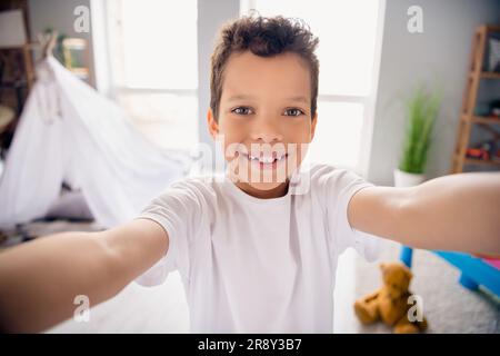 Ritratto di ragazzo positivo fare selfie parlare con i nonni mostrare la sua stanza da gioco al chiuso Foto Stock