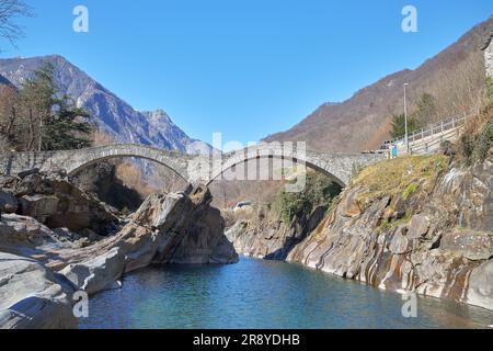 Questa è un'immagine del ponte medievale a doppio arco conosciuto come Ponte dei salti che attraversa il fiume Verzasca nella pittoresca cittadina Foto Stock