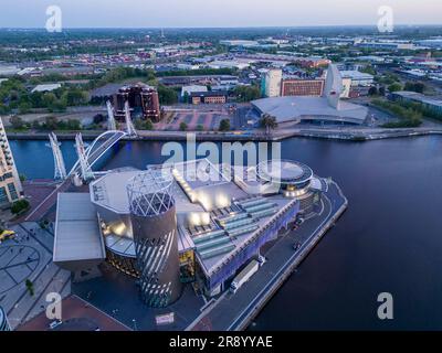Vista aerea del Lowry Centre e dell'Imperial War Museum al tramonto, Salford Quays, Manchester, Inghilterra Foto Stock