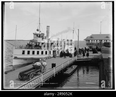 Str. Isola di Frontenac Wharf, Round Island, N.Y., tra il 1890 e il 1901. Passeggeri in attesa della nave Thousand Island Steamboat Company - biglietti ferroviari e piroscafi in vendita dall'ufficio postale sulla destra. St Lawrence River. Foto Stock