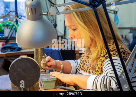Olanda, orafa donna in officina progetta e lavora su un bracciale nel suo studio. Foto Stock